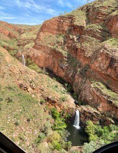 Once it passed, we enjoyed watching a beautiful rainbow appear over the lake. We set off again and flew through another rainbow in the middle of the lake.

As we tracked through the Carr Boyd Ranges Western Gorges we began to see big streams of white coming out of the hills in every direction. We were so excited as we flew over our first 3 stage waterfall.